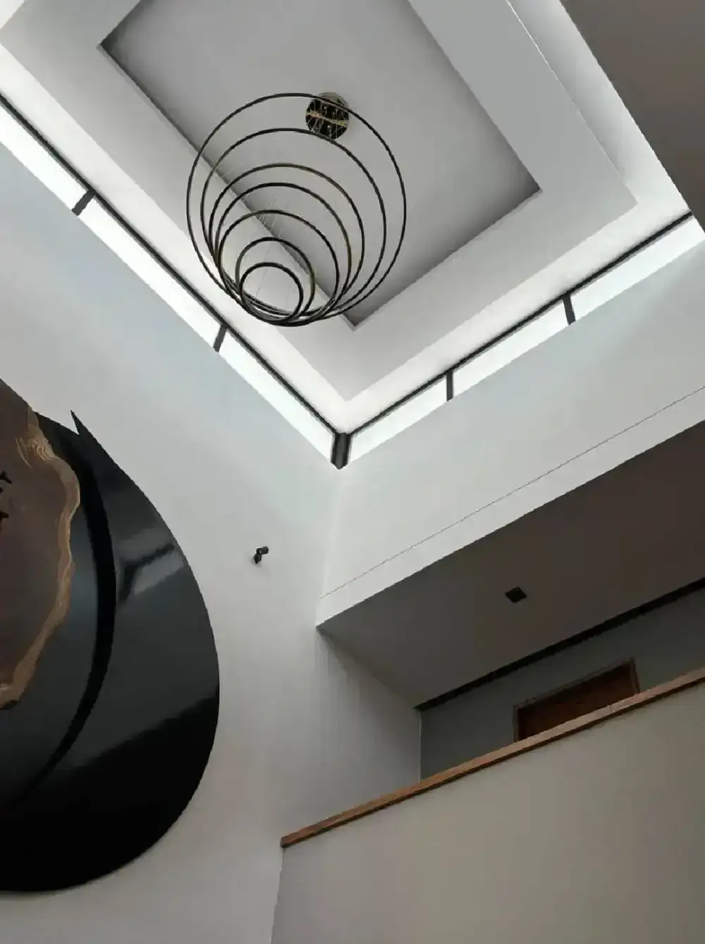 Doble altura con tragaluz y lámpara circular en Casa Sagrado Corazón, El Campanario, Querétaro