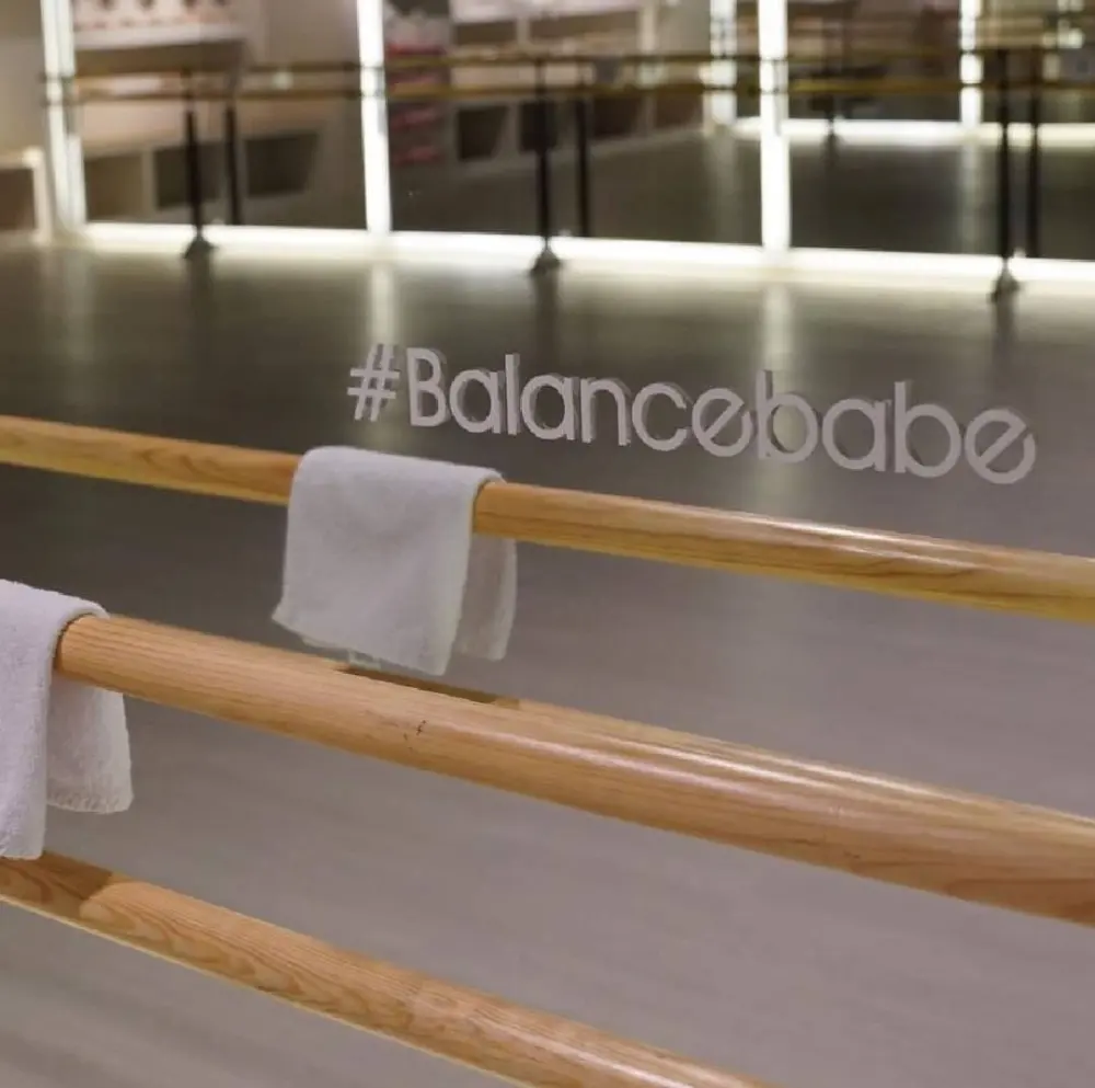 Detalle del hashtag Balancebabe grabado en el espejo junto a las barras de ballet, construcción del negocio en Querétaro