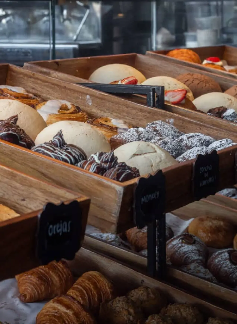 Detalle de piezas de pan dulce en charolas de madera durante la creación del negocio gastronómico Pan de Lucio
