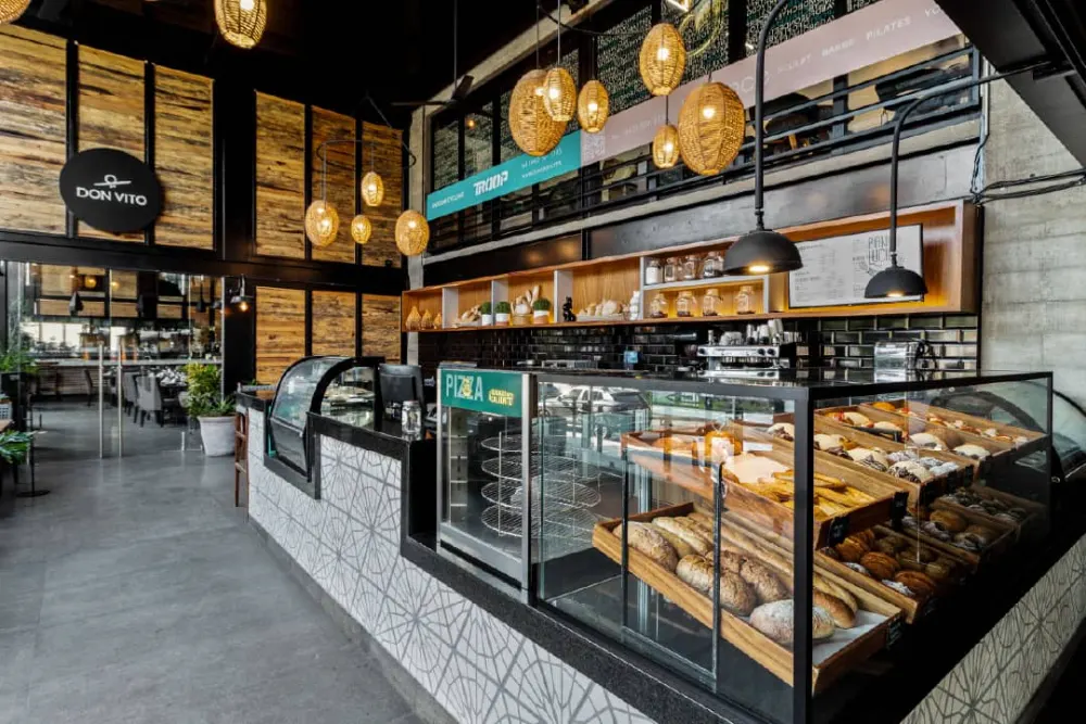Barra de servicio y anaqueles de madera en el diseño interior de la panadería Pan de Lucio