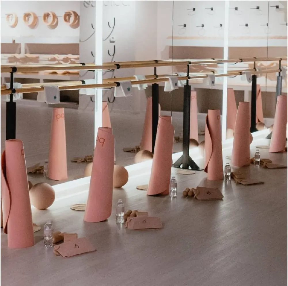 Barras de ballet con tapetes rosas dispuestos en el piso, diseño de interiores del local comercial Balance