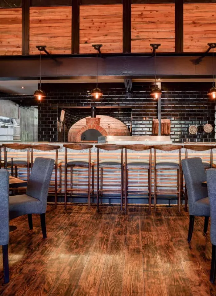 Horno italiano artesanal y barra con sillas en el restaurante Don Vito en Querétaro