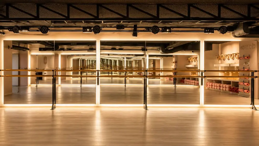 Salón de barre con espejos, barras y tapetes de práctica en el proyecto comercial Balance en Querétaro