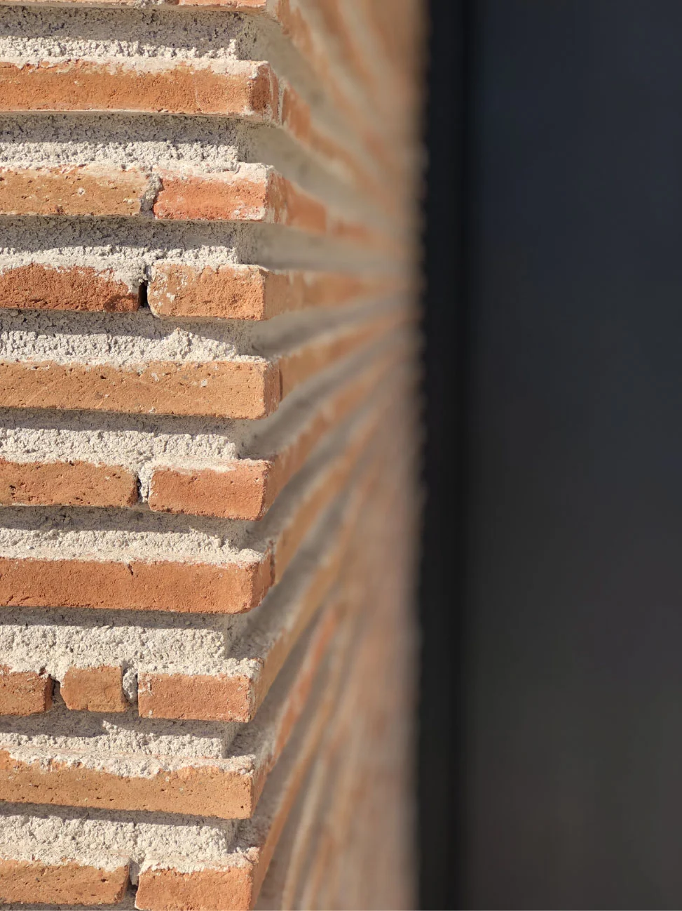Esquina de ladrillo aparente junto a carpintería negra, ejecutada con control y supervisión de obra