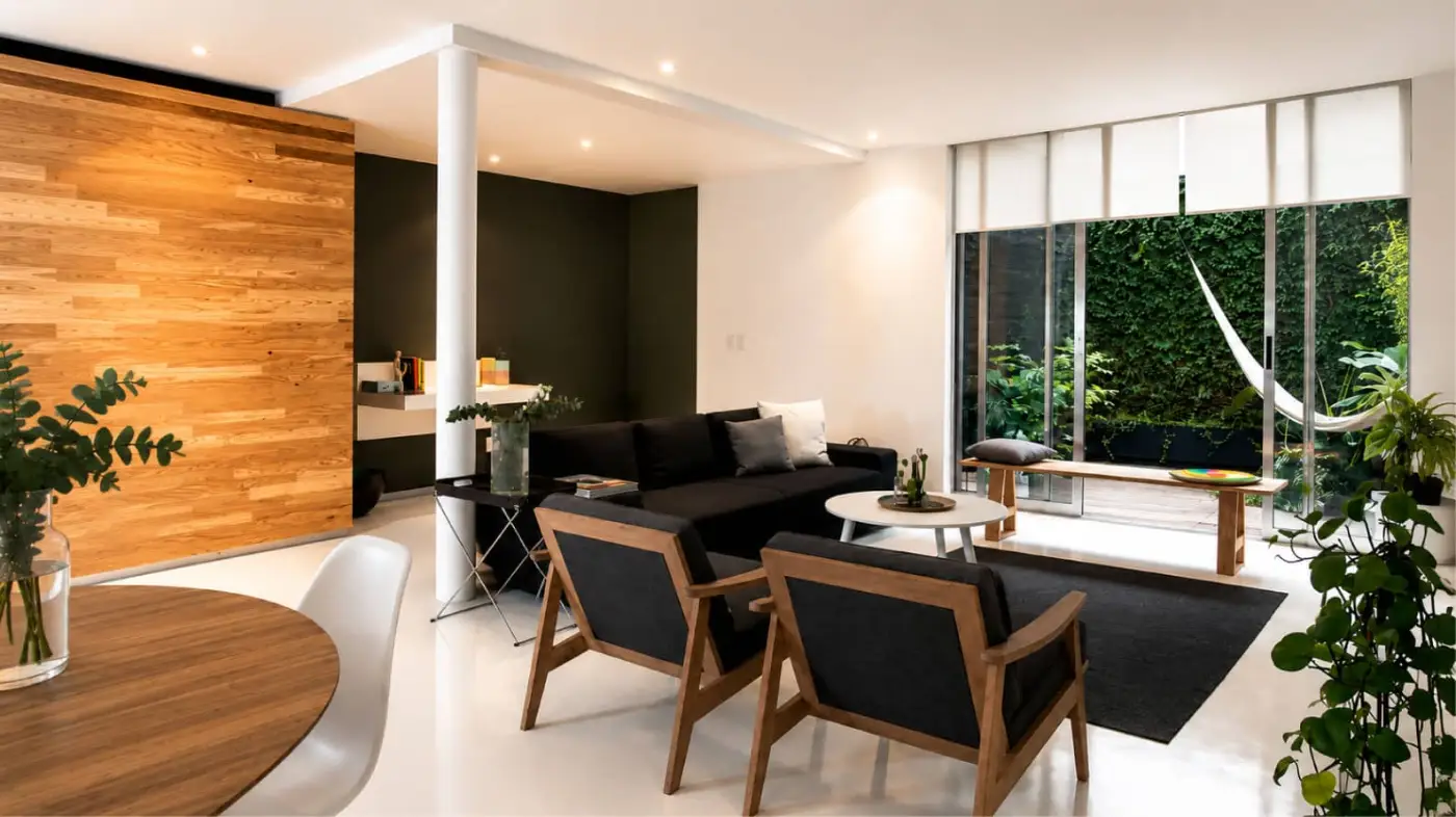 Departamento 2018 — sala, comedor y patio de luz Sala y comedor de Departamento 2018, remodelación residencial en Ciudad de México con muro de madera y patio de luz
