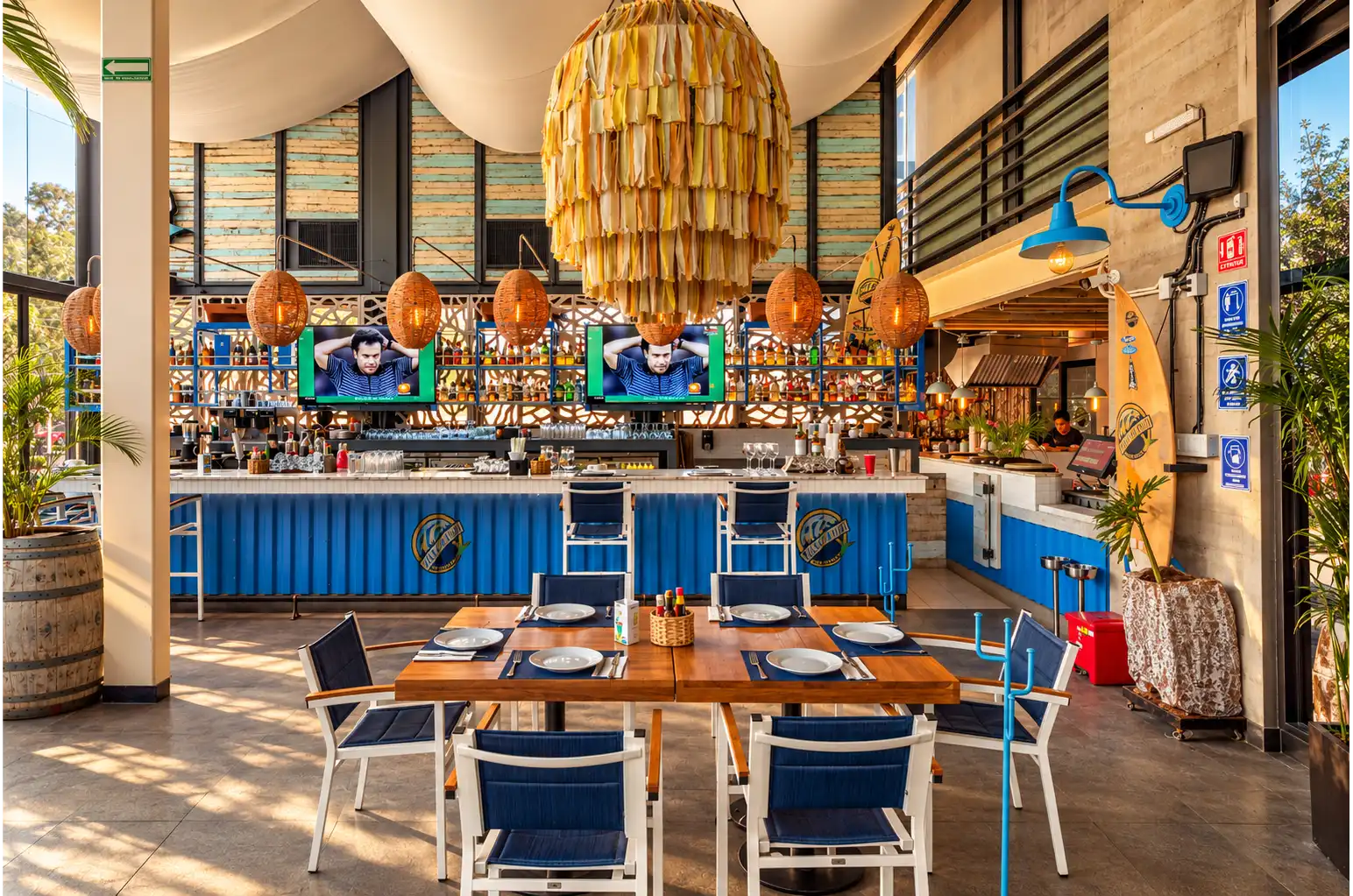 Vista general del comedor y la barra con contenedor azul del restaurante moderno Yellow Fish en Querétaro