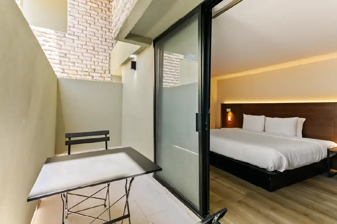 Terraza privada con mesa plegable y puerta corrediza hacia la recámara en propiedad remodelada en Querétaro