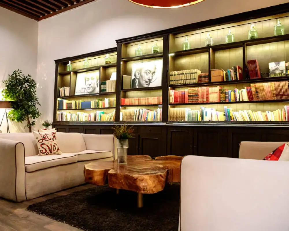 Biblioteca con librero iluminado y sala de estar en el Mesón Santa Rosa, Querétaro