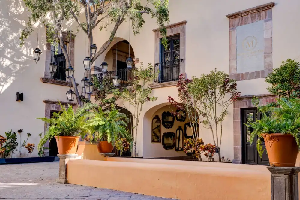 Patio interior con jardineras y letrero del Mesón Santa Rosa en Querétaro