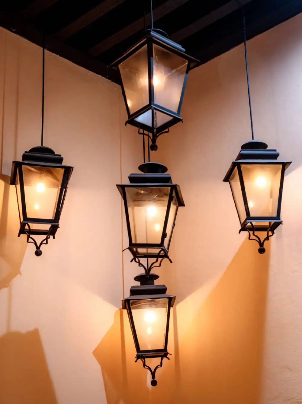 Faroles de herrería colgantes iluminados en un corredor del Mesón Santa Rosa