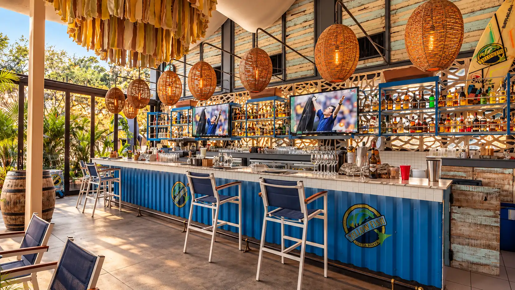 Yellow Fish — diseño arquitectónico de restaurante en Querétaro Barra exterior del restaurante Yellow Fish en Querétaro con lámparas de palma tejida, techo de palapa y mobiliario azul